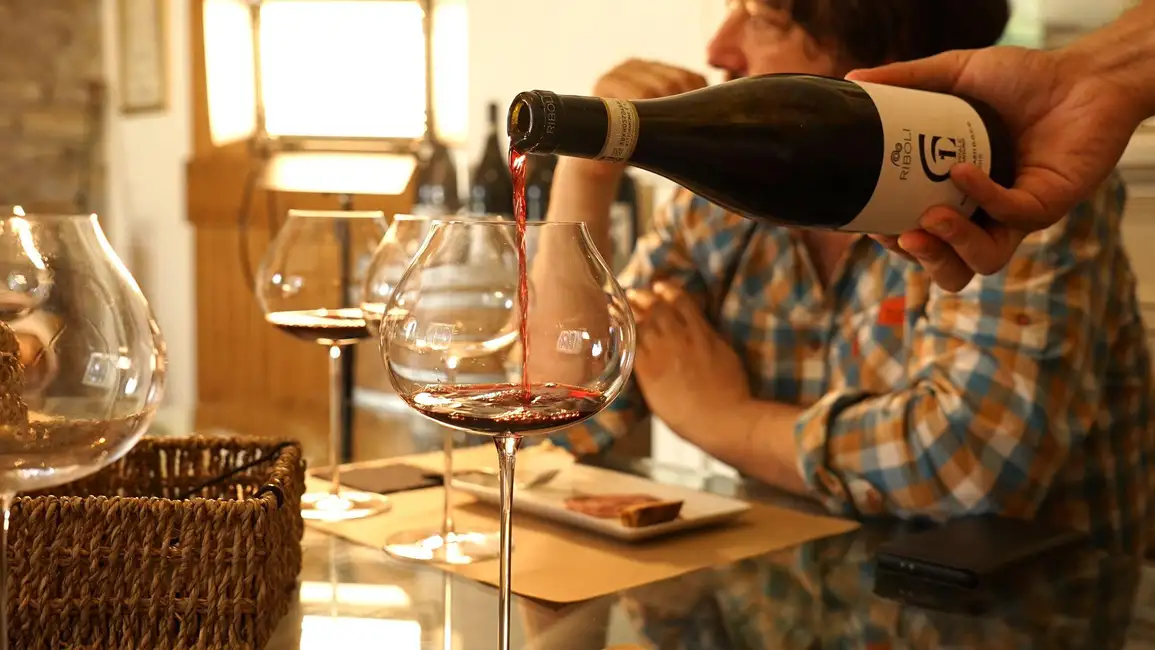 Host sefving wines for tasting in cantina Ribo,ni, Piedmont